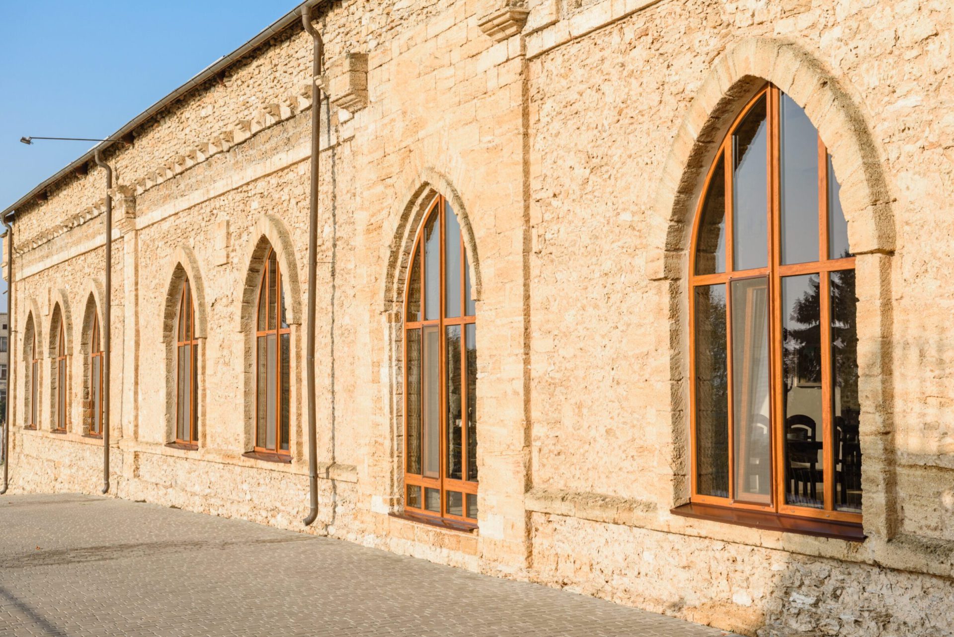 Arched timber windows set into a restored stone elevation