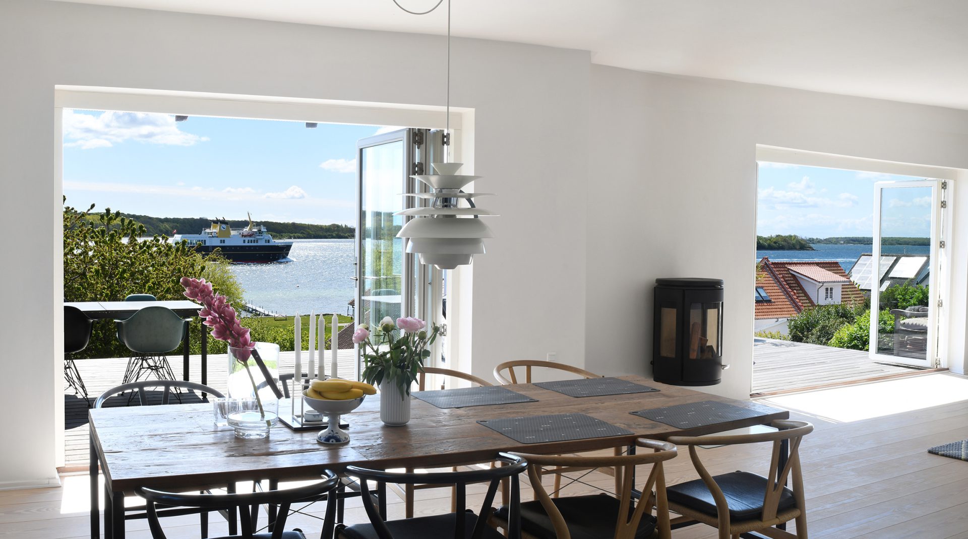 Interior dining space with folding doors to a waterside view