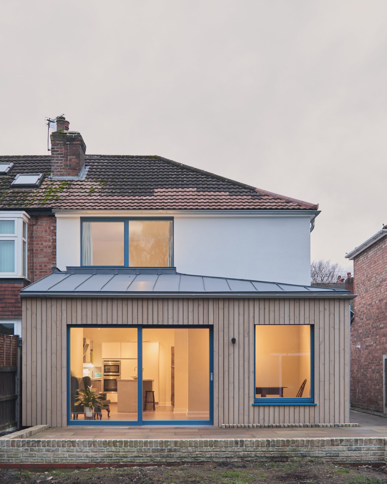 The rear of the retrofitted 1930s semi, new timber cladding and glazing against the original brickwork