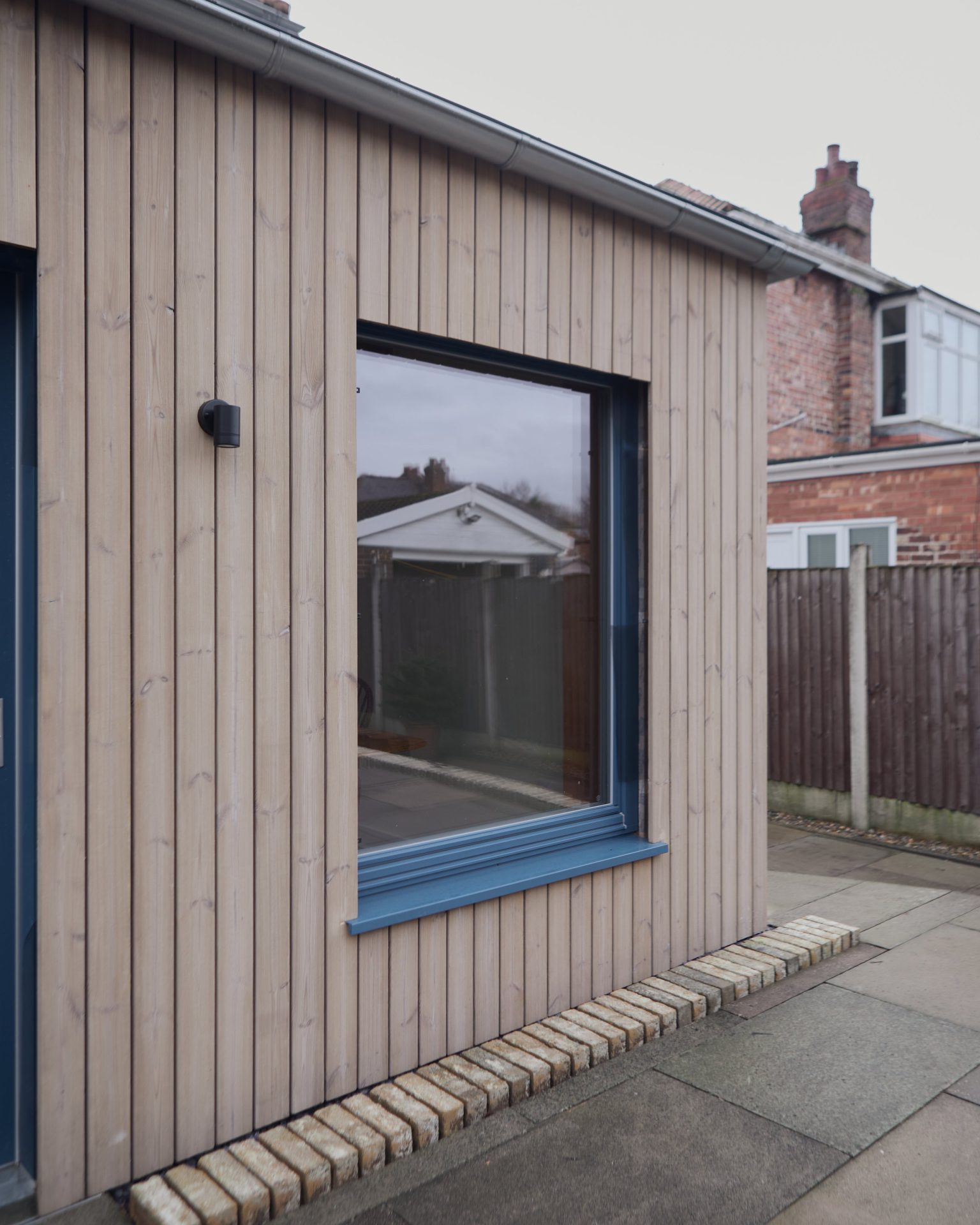 A triple-glazed window set into vertical timber cladding