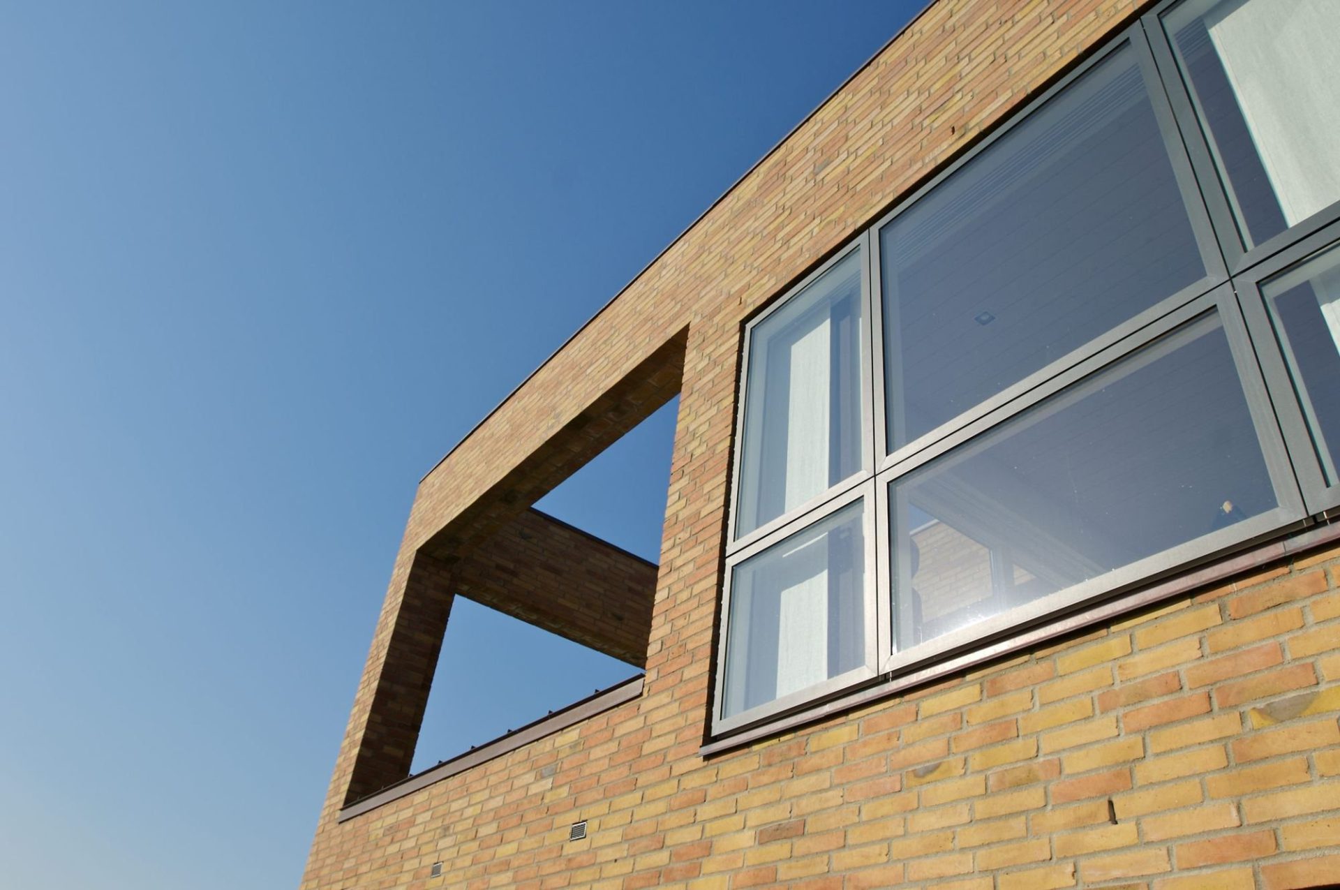 VELFAC 200 windows set into a brick facade against a blue sky