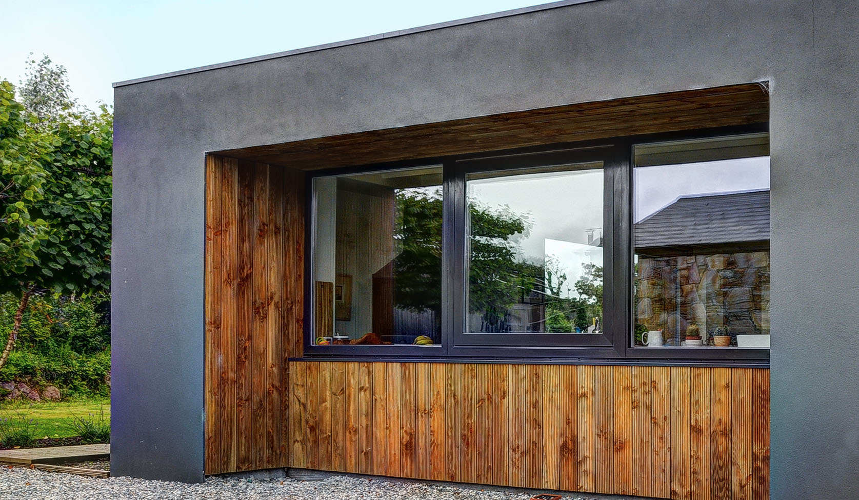 Timber clad elevation with a deep reveal aluminium window